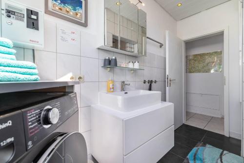a bathroom with a sink and a washing machine at Haus Fabio in Großengstingen