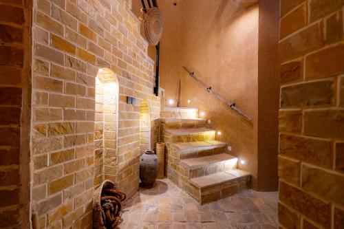 a hallway with stairs in a brick wall with lights at Omani Guest House نزل البيت العماني in Nizwa