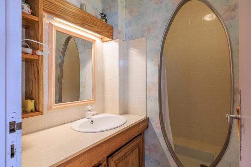a bathroom with a sink and a mirror at L'Etable de Sauvignac - Avec piscine privée in Sauvignac