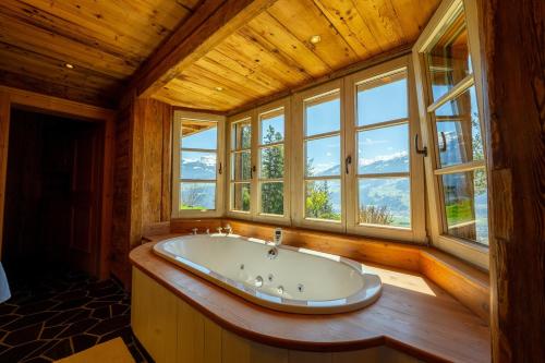 a large bath tub in a room with windows at Jagdhaus Umlberg in Umlberg