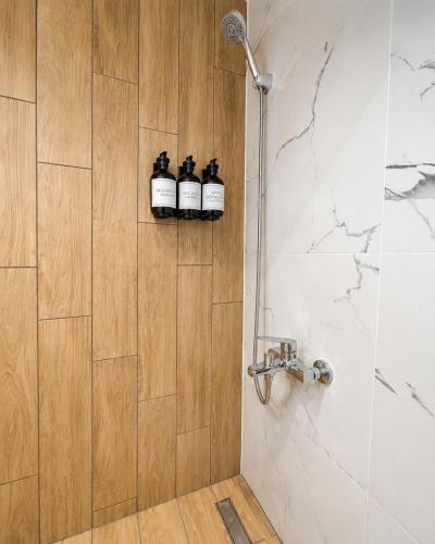 a bathroom with a shower with three bottles on the wall at AZEK Garden Suite in Perea