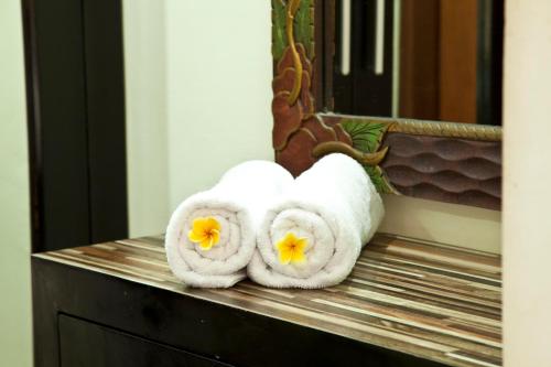 Un par de toallas sentadas en un mostrador frente a un espejo. en Jepun Bali Hotel, en Kuta