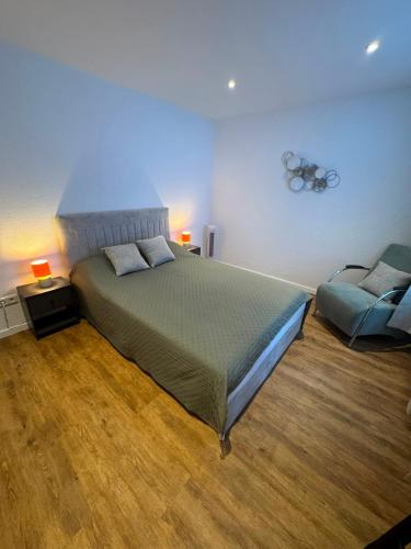a bedroom with a large bed and a chair at Gemütliche City Wohnung in Mönchengladbach