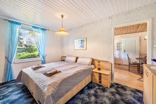 a bedroom with a large bed with blue curtains at Bungalow an der Havel in Margarethenhof
