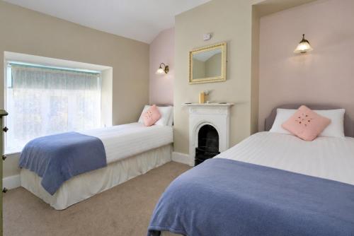 two beds in a room with a fireplace at Finest Retreats - Artro View in Llanbedr