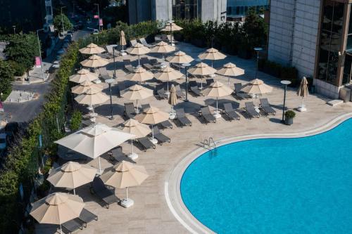 a group of umbrellas and chairs next to a pool at Radisson Blu Hotel, Istanbul Sisli in Istanbul
