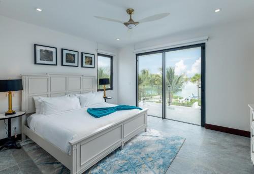 a bedroom with a white bed and a large window at Pestica Villa Private Pool in Leeward