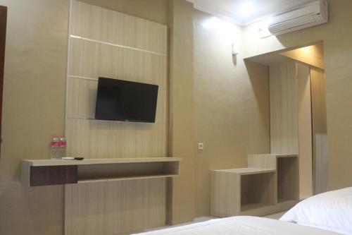 ein Schlafzimmer mit einem TV an der Wand in der Unterkunft Cyka Raya Hotel in Wonosari
