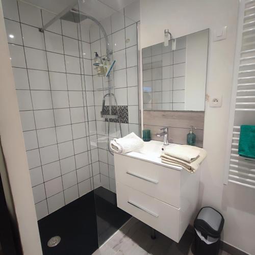 a white bathroom with a sink and a mirror at Little studio in the old town in Vence