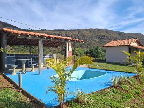 a swimming pool in a yard with a pergola at Pouso Canarinho in Carrancas