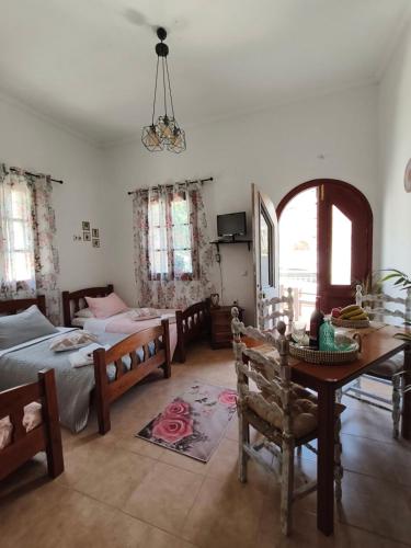 a bedroom with two beds and a table and chairs at Lerios in Vrachonisída Savoúra