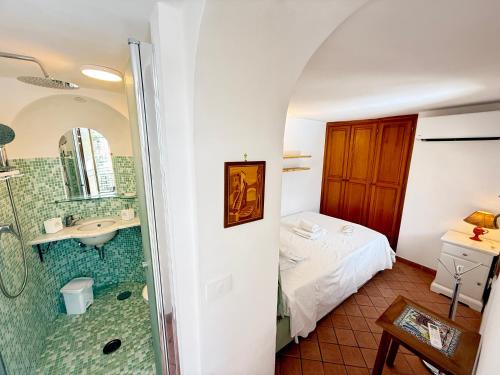 a bathroom with a shower and a bed and a sink at Domus Floris in Positano