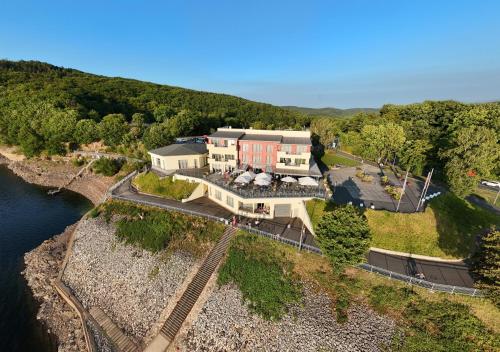 an aerial view of a building next to a river at Dormio Hotel Der Seehof in Heimbach