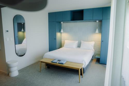 a bedroom with a white bed and a wooden table at Apparté Plus in Brive-la-Gaillarde