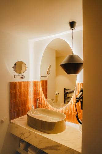 a bathroom with a round sink and a mirror at Apparté Plus in Brive-la-Gaillarde