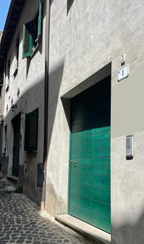 a green garage door on the side of a building at Borgo nel Centro in Ronciglione