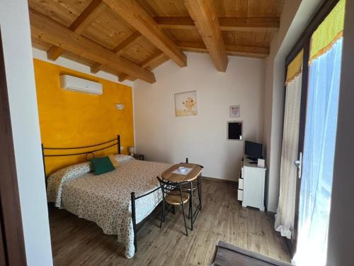 a small bedroom with a bed and a table at Il Melarancio in Pescia Romana