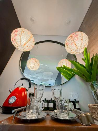 a table with glasses and a kettle and a mirror at Alquimia House tu refugio en Santa Ana in Corrientes