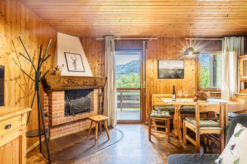 a living room with a fireplace and a dining table at Betù Holiday Apartment in Castello di Fiemme