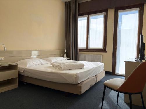 a hotel room with a bed and a chair at Hotel Bristol in Riva del Garda
