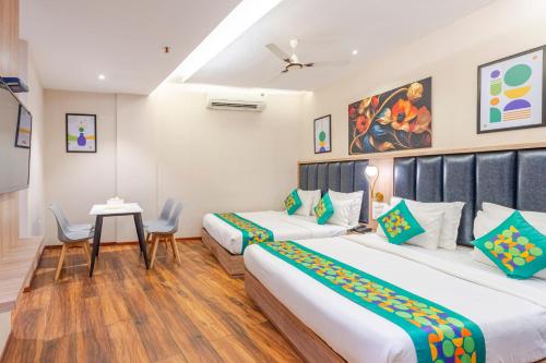 a hotel room with two beds and a table at Treebo Premium Widlor Boutique with Swimming Pool in Mumbai