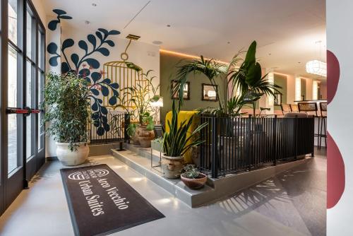 Eine Lobby mit Topfpflanzen und einem Schild auf dem Boden. in der Unterkunft Arco Vecchio Urban Suite - Epoca Collection in Lecce