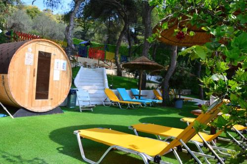 a yard with a table and chairs and a barrel at New Aegli Resort Hotel in Poros