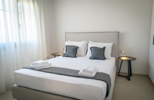 a bedroom with a large white bed with towels on it at Villa Selina 2 - Etheras Properties in Kythira