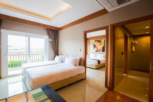 a hotel room with a bed and a balcony at Romantic Khon Kaen Hotel in Khon Kaen