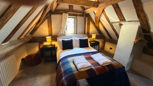 a bedroom with a large bed in a attic at Taylour House - Edenbridge, sleeps 10, historic, unique yet modern in Kent
