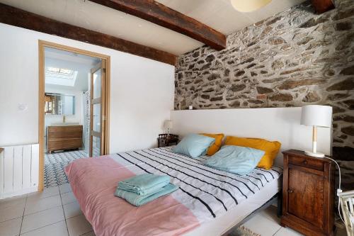 a bedroom with a bed and a stone wall at Chambre de garel in Le Minihic-sur-Rance