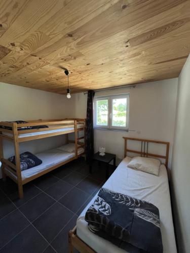 a bedroom with two bunk beds and a wooden ceiling at Villa Vallon Pont d'Arc in Vallon-Pont-dʼArc