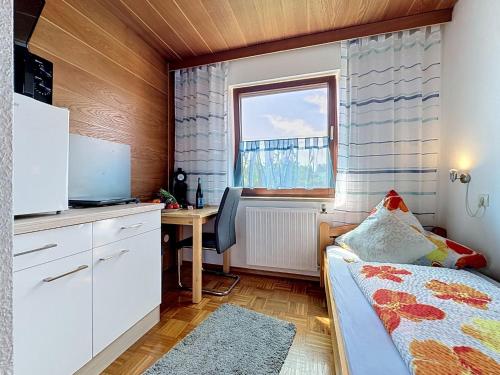 a bedroom with a bed and a desk and a window at Studio Sirch-1 by Interhome in Diedorf