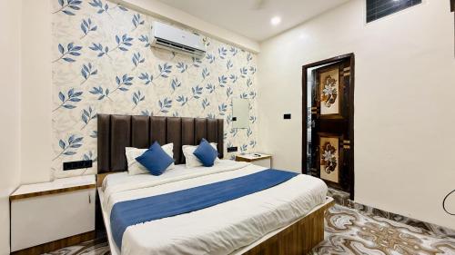 a bedroom with a large bed with blue pillows at Hotel Aashirwad in Indore