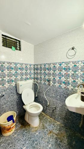 a bathroom with a toilet and a sink at Hotel Aashirwad in Indore