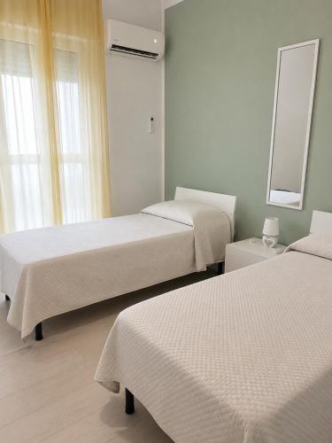 a room with two beds and a mirror at Aurea Suites in Palermo