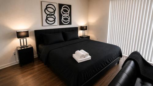 a bedroom with a black bed with two towels on it at Luxe Nest King Studio Downtown 2B3 in Birmingham