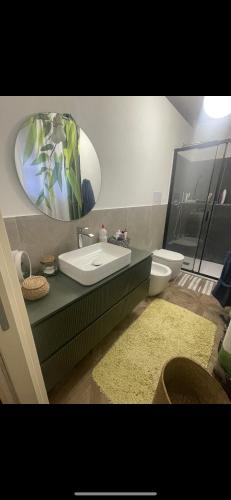 a bathroom with a sink and a toilet and a mirror at La casa al mare in Palermo
