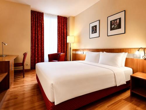 a large white bed in a hotel room at HOTEL de la POSTE in Esch-sur-Alzette