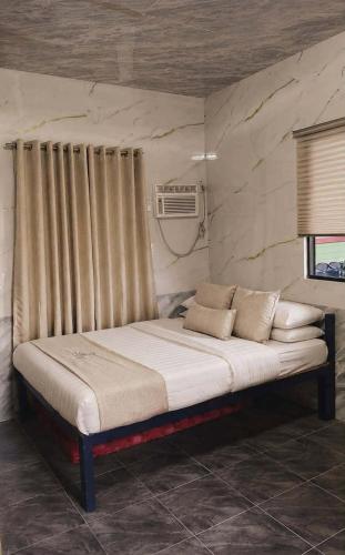 a large bed in a room with a window at Lhady Roxy in Siquijor