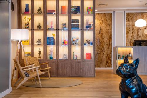 a room with a chair and a cabinet of vases at INNSiDE by Meliá Costablanca in Benidorm