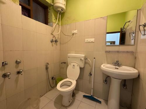 a bathroom with a toilet and a sink at Hotel Backpacers Mcleodganj in McLeod Ganj