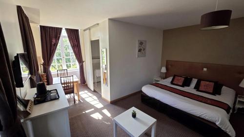 a hotel room with a large bed in a room at Hotel du Golf de Clécy in Clécy