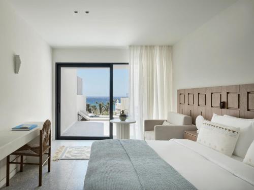 a hotel room with a bed and a view of the ocean at Tinos Beach Hotel in Kionia