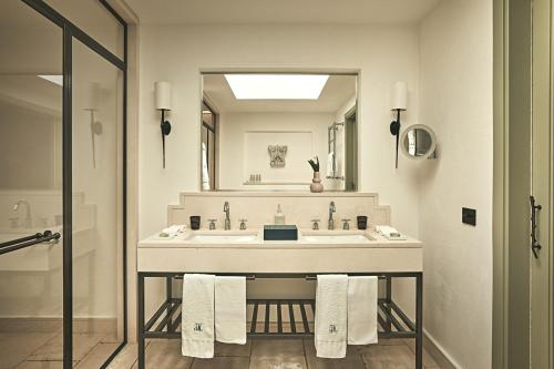 a bathroom with a sink and a large mirror at Rocco Forte Masseria Torre Maizza in Savelletri di Fasano