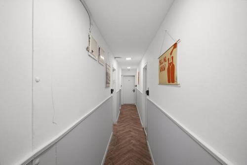 a hallway in a building with white walls and paintings at Localz House- Trumpeldor Beach in Tel Aviv