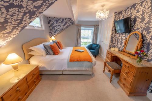 a bedroom with a bed and a vanity and a mirror at Ty Derw B & B in Dinas Mawddwy