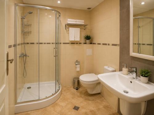 a bathroom with a shower and a toilet and a sink at Hotel Topalovi in Nesebar