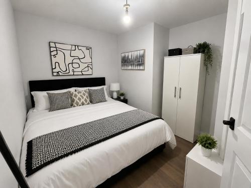 a bedroom with a large bed and a white cabinet at 3 Bed House , Bootle , Discounts , Long Stays , Contractors , Families , Relocation Stays in Liverpool