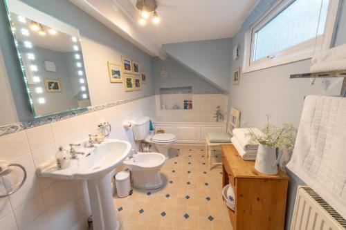 a bathroom with a sink and a toilet and a tub at Ty Derw B & B in Dinas Mawddwy
